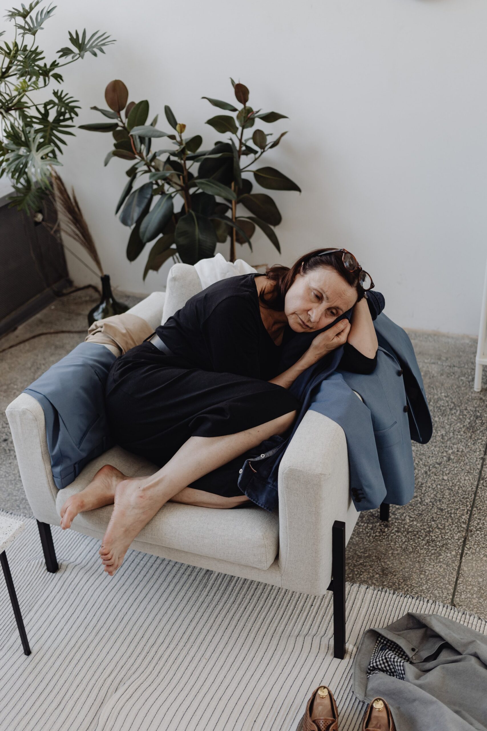 A woman lying curled up in an armchair