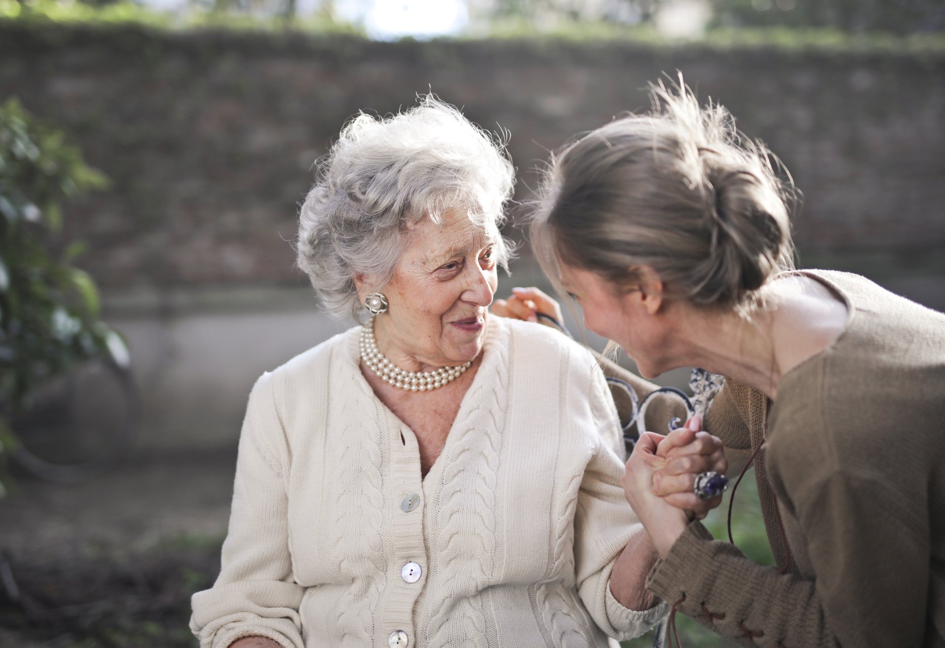 An older woman being comforted by another woman
