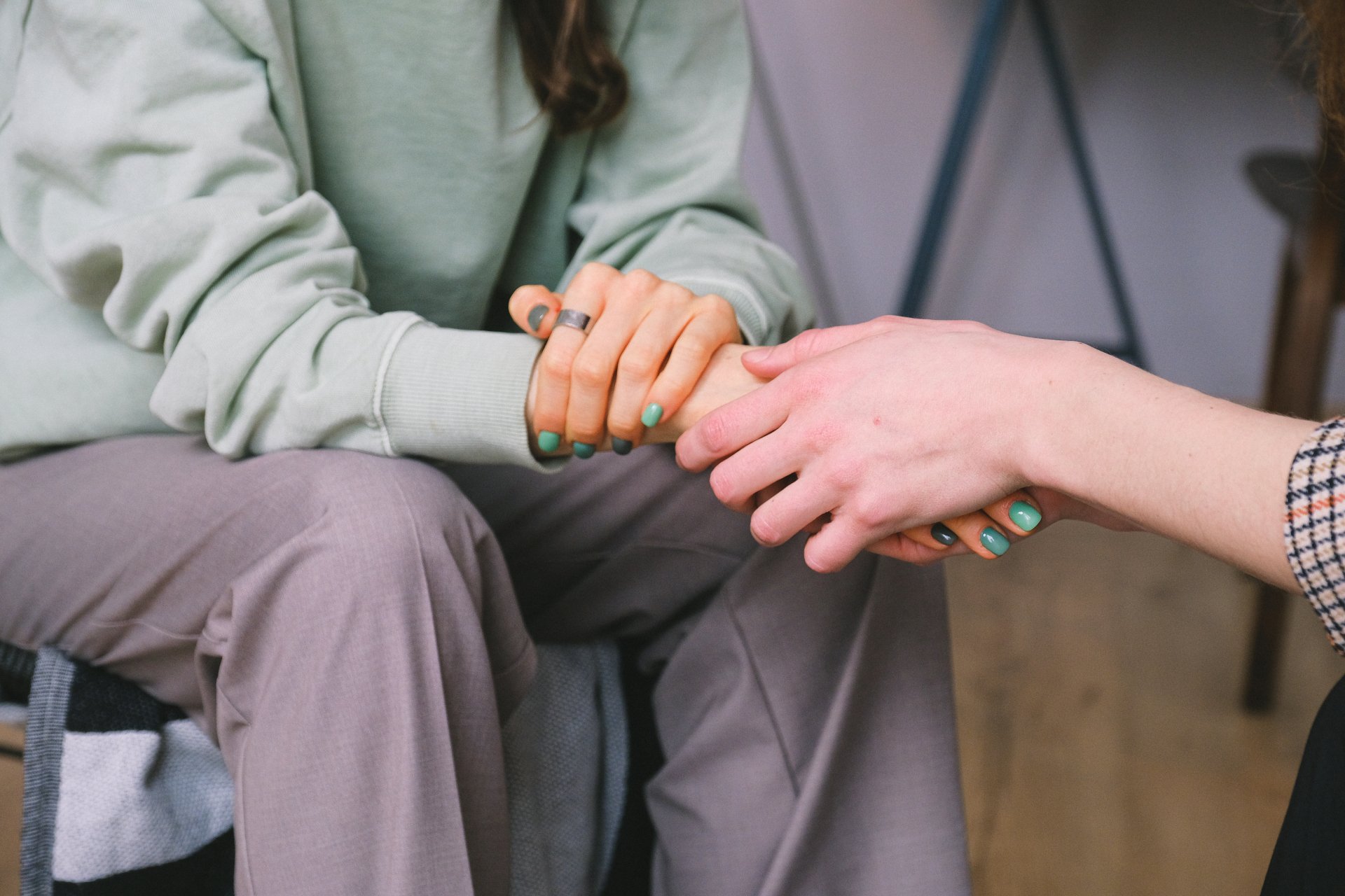 Two people holding hands in a gesture of comfort